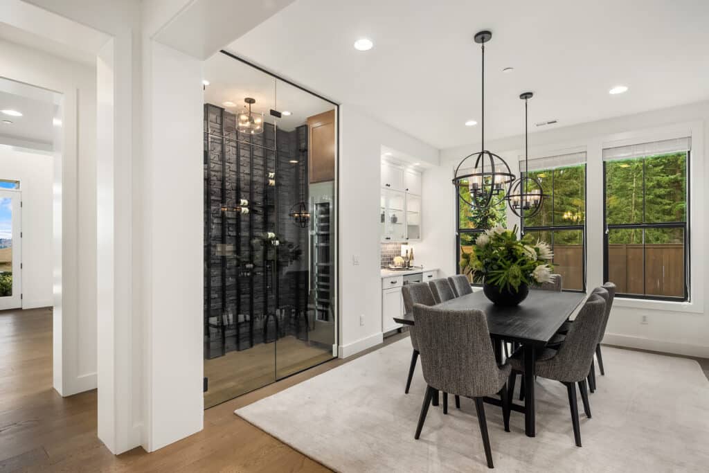 Modern dining room with wine cellar and large windows.