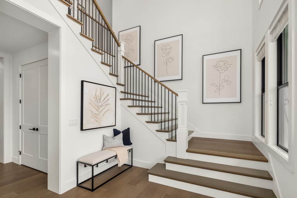 Modern staircase with framed wall art and bench