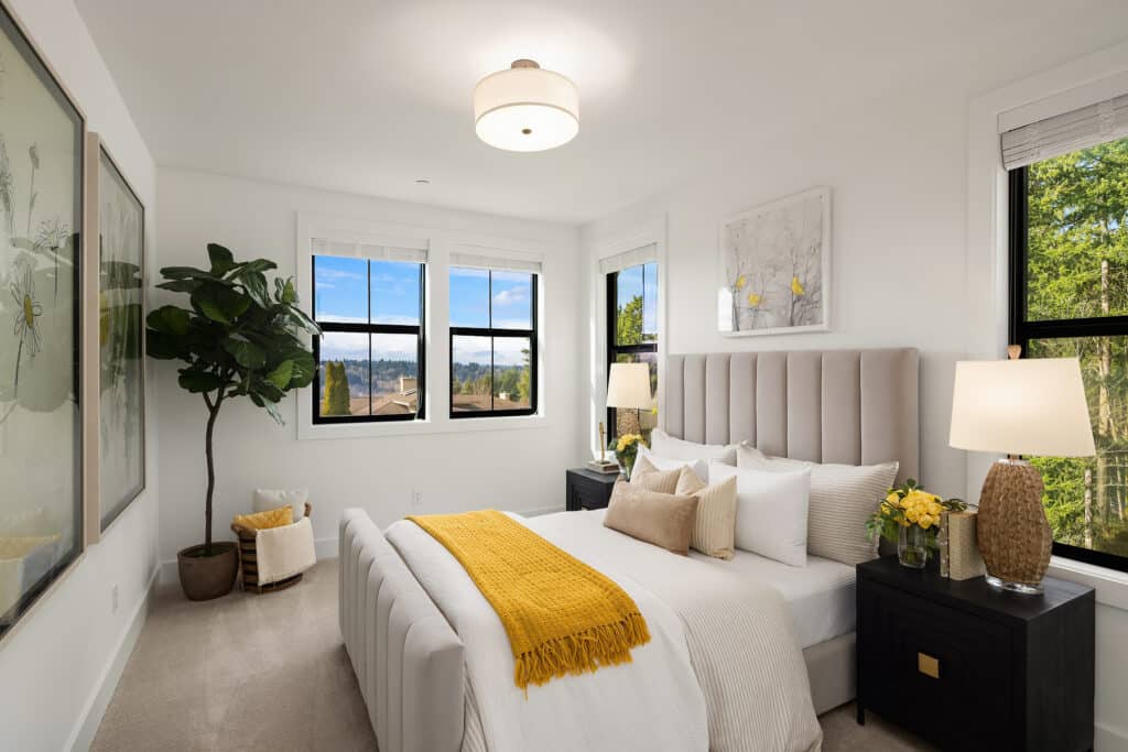 Modern bedroom with large windows and yellow accents.