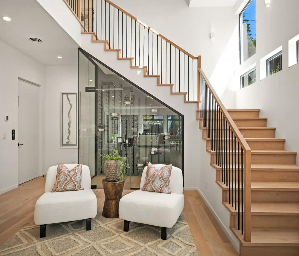 Modern living room with staircase and two chairs.