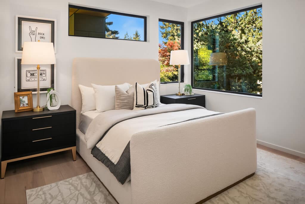 Modern bedroom with large windows and decor.