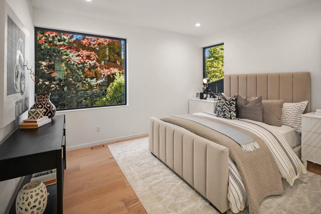 Modern bedroom with large windows and stylish decor.