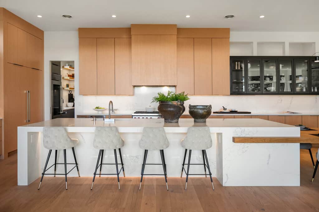 Modern kitchen with wooden cabinets and island seating.