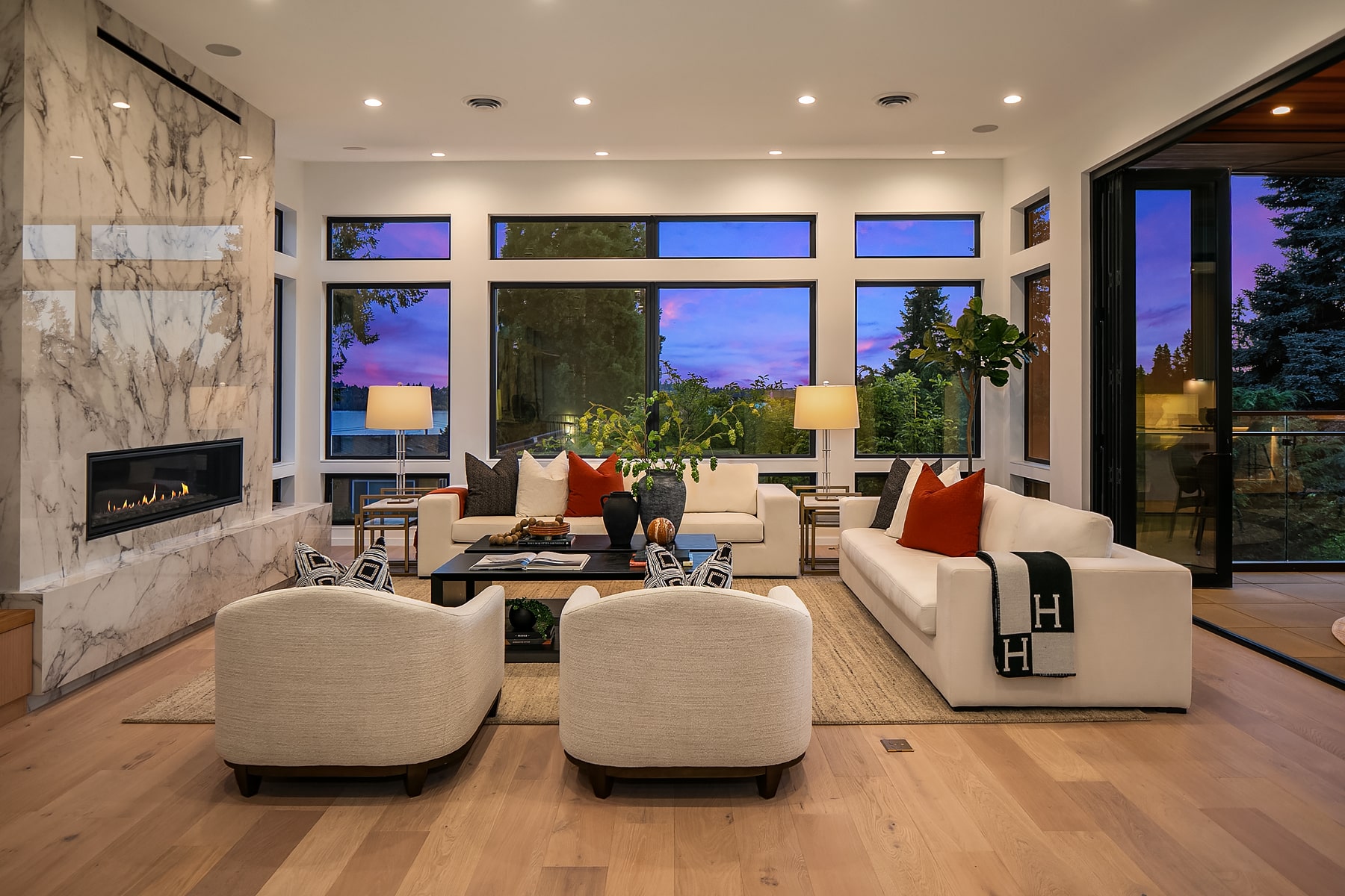 Modern living room with fireplace and large windows.