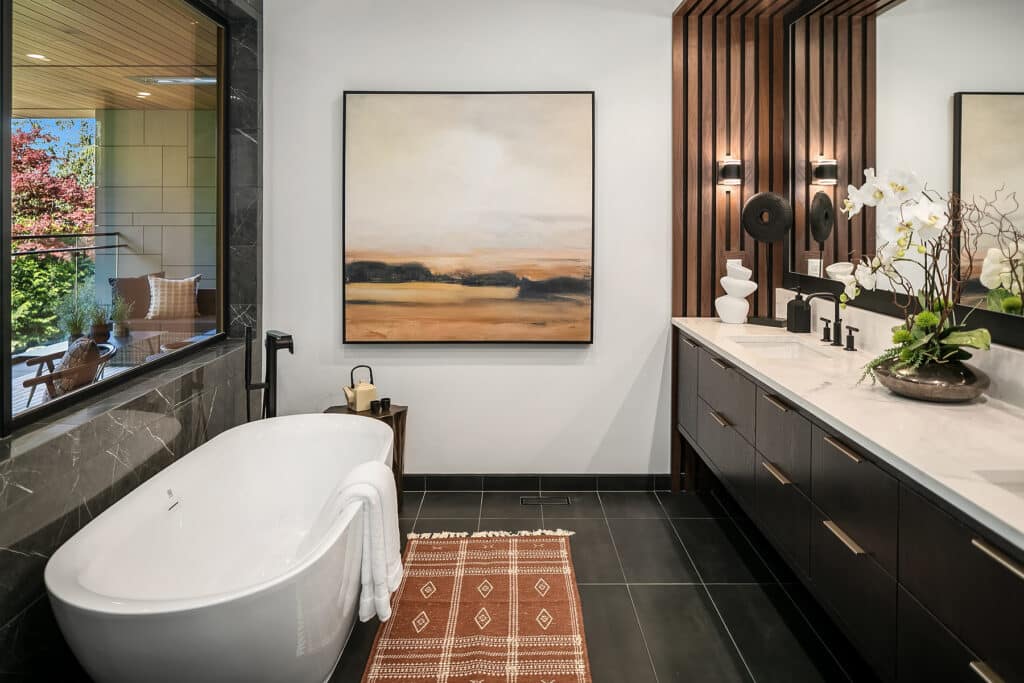 Modern bathroom with tub and large window.